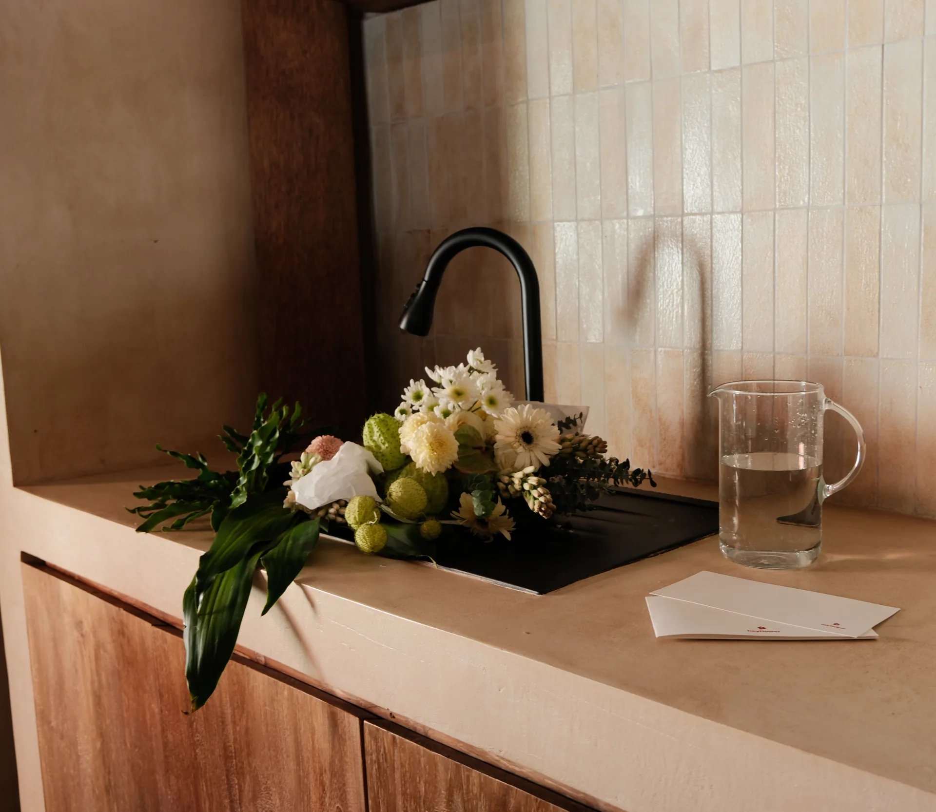 Cream and white bouquet resting in a kitchen sink before being trimmed