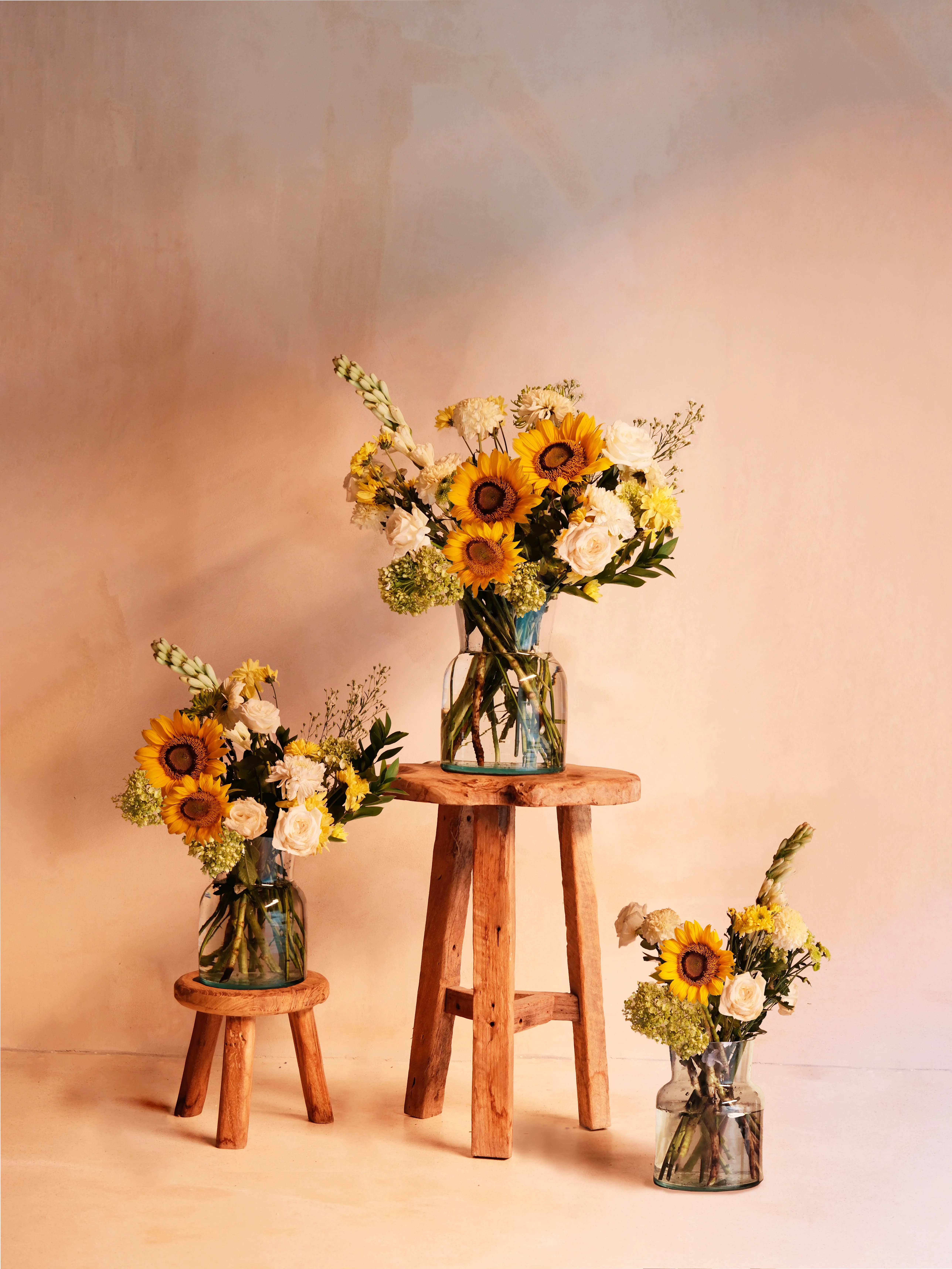 Three yellow bouquet sizes on wooden stools